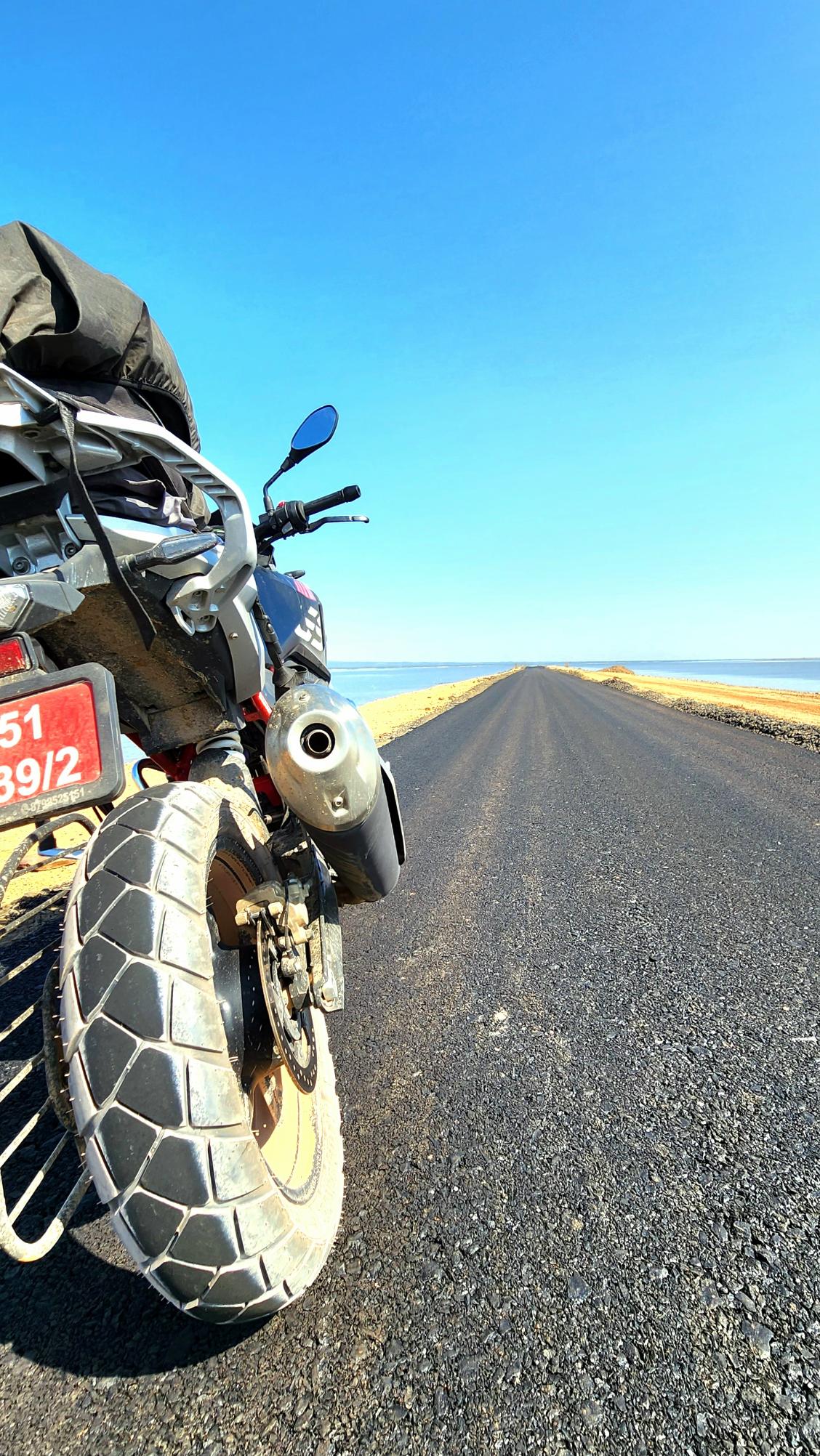 Motorcycle detail on an open road.
